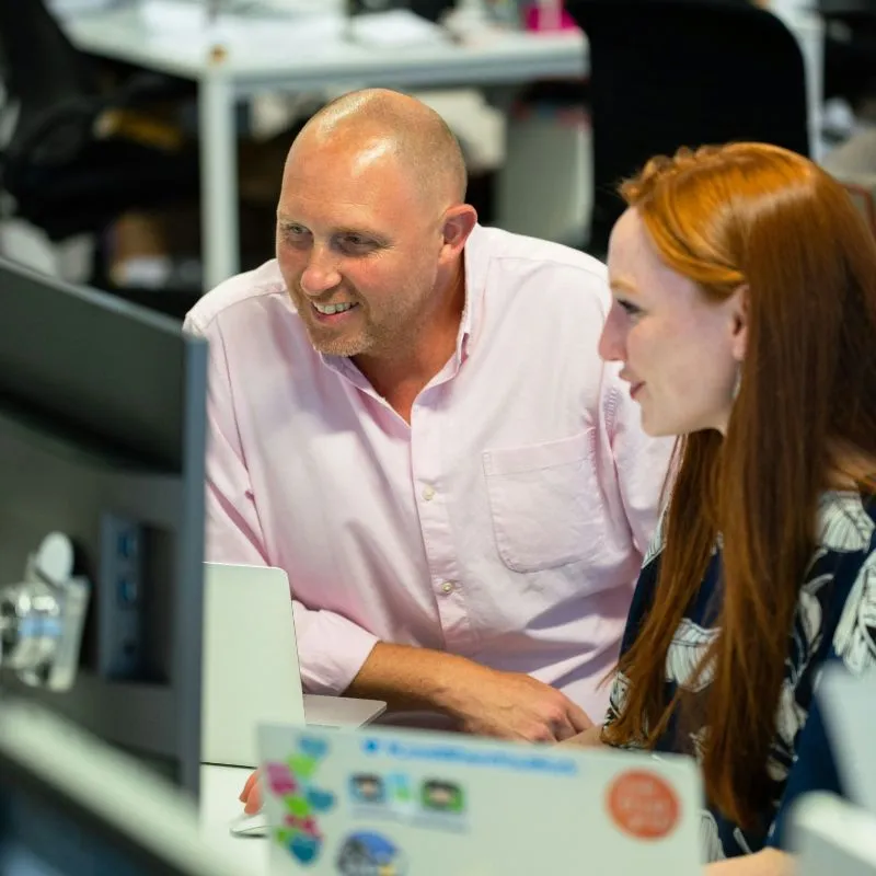Two Firefinch colleagues talking at a desk